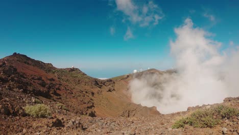 vista de un paisaje volcánico con el cielo azul claro en el fondo - el polvo se eleva desde el cráter, ruque de los muchachos, la palma, españa