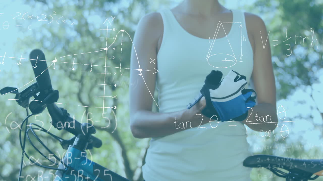 woman adjusting cycling gloves near bike in sunny park, showing animated math graphs for education