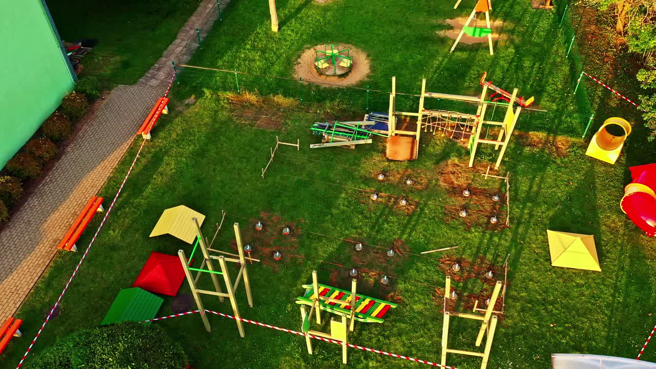 Terrain de jeux en construction avec des structures d’escalade en bois et un terrain en herbe à l’heure dorée