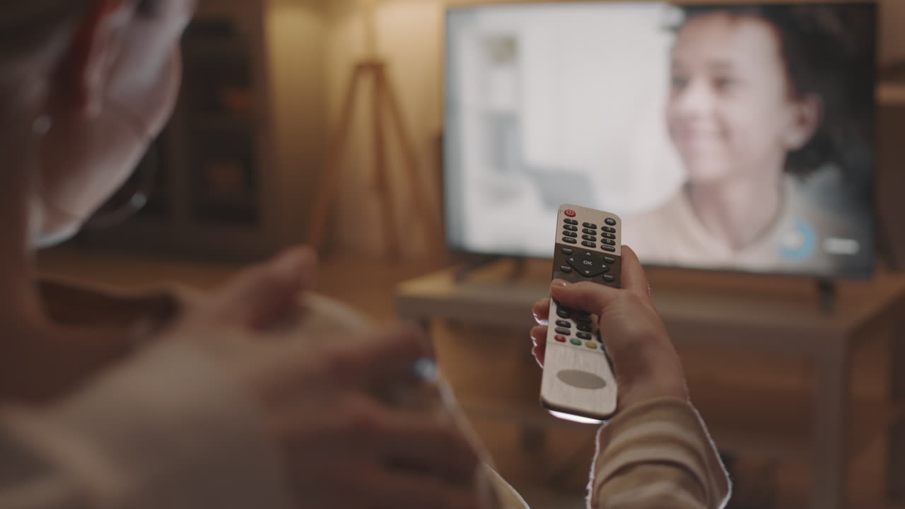 Person Turning TV Volume Up