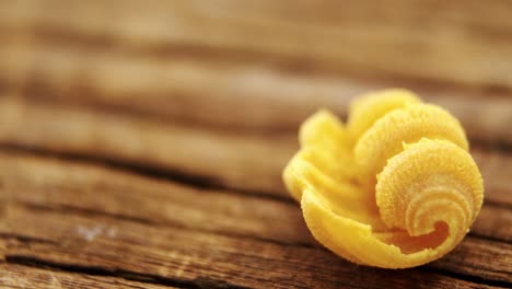 yellow conchiglie pasta on wooden table