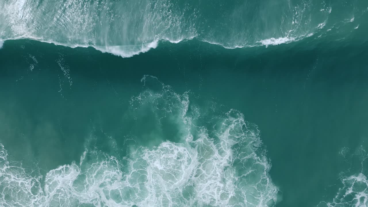 Aerial View Of Foamy Waves Coming Onto The Beach In Nazare, Portugal