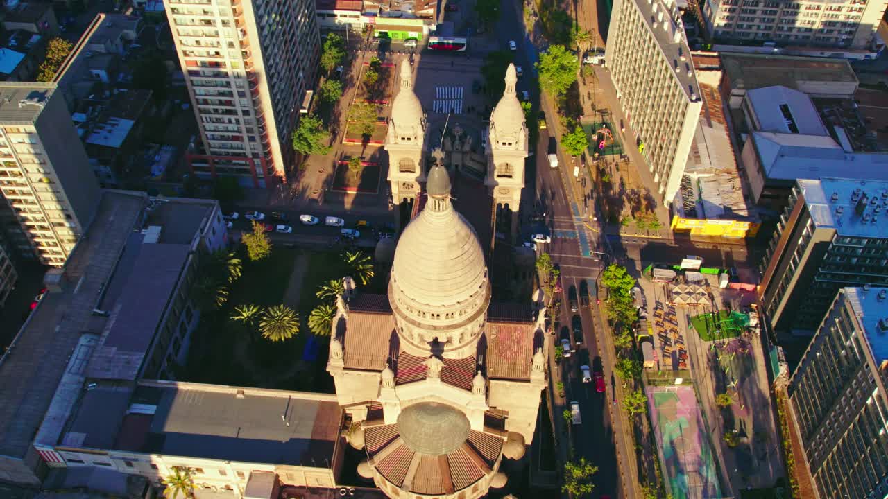 High angle aerial around the sunlit Bas&iacute;lica de los Sacramentinos, in Santiago de Chile