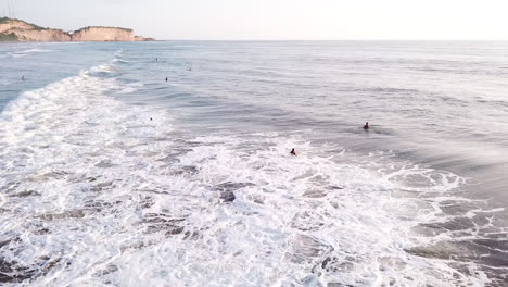 Poderosa-Oleada-De-Agua-De-Mar-Con-Surfistas-En-Su-Superficie-Durante-El-Verano-En-La-Playa-De-Olon,-Ecuador