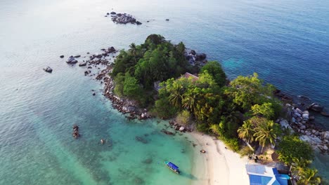 Great-Aerial-view-of-a-Hut-on-a-tropical-Sole-peninsula-with-turquoise-water-and-lush-green-vegetation