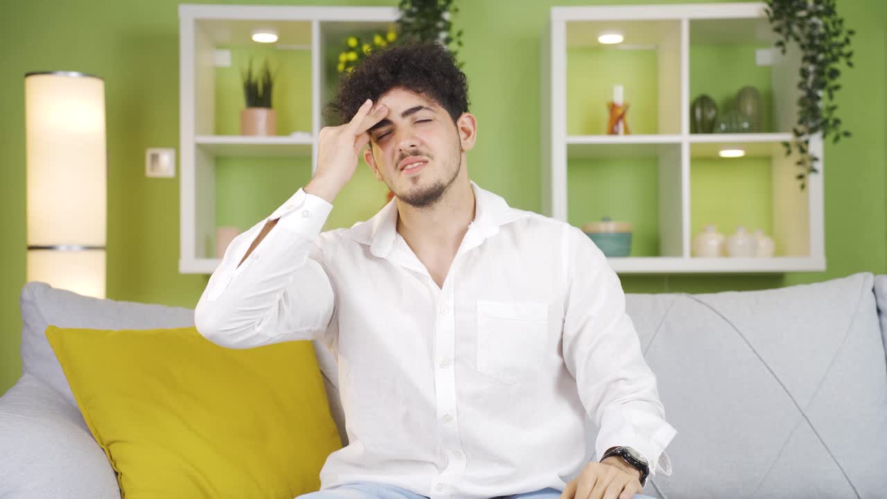 젊은이가 두통을  ⁇ 고 있습니다.