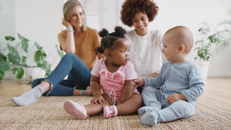 Dos-Madres-Reunidas-Para-Jugar-Con-Bebés-En-Casa-En-Un-Apartamento-Tipo-Loft