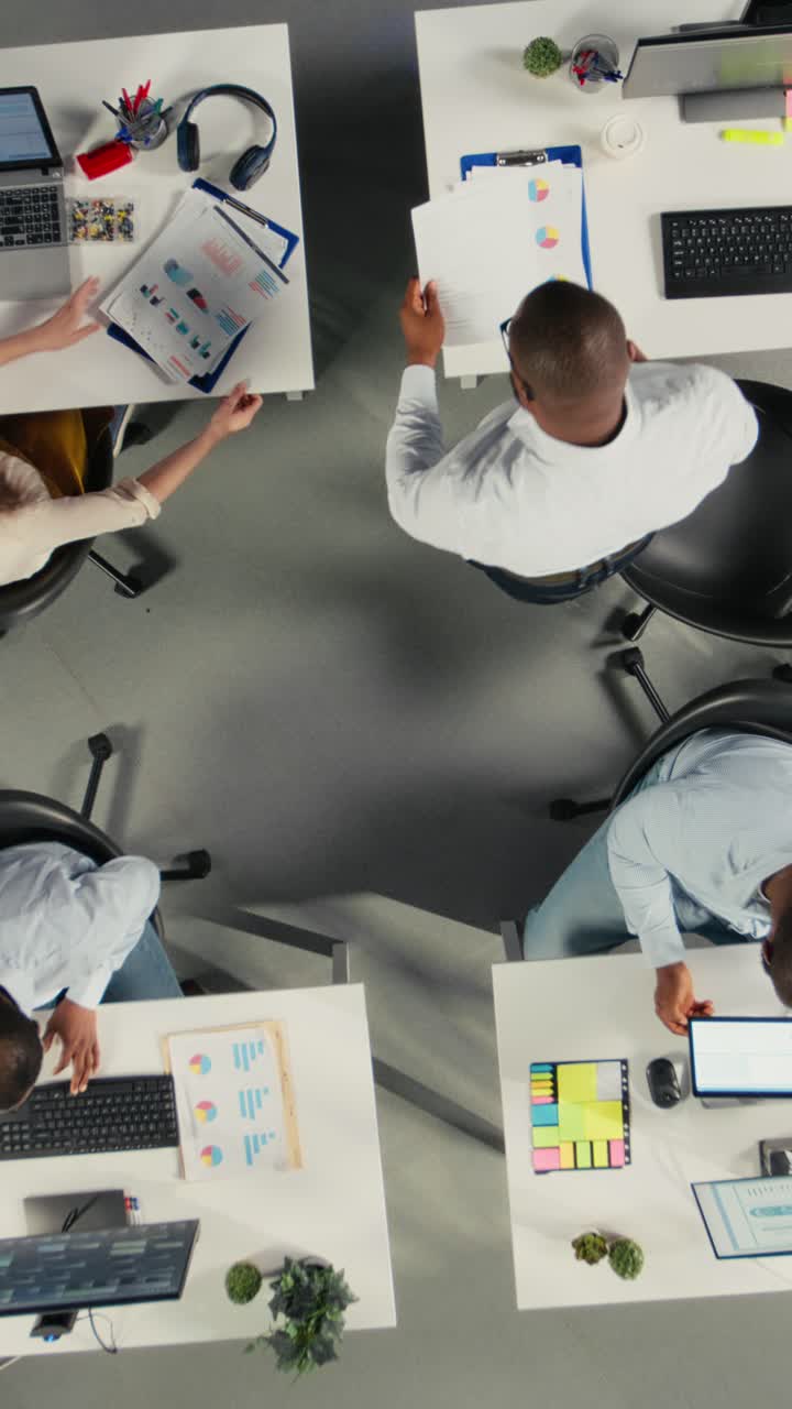 Vertical Video Top down view zoom in of staff in office discuss business strategy