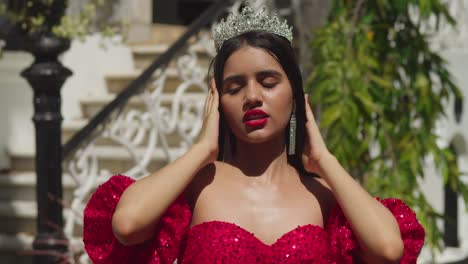 En-Medio-De-Los-Susurros-De-La-Historia-En-Un-Castillo-Caribeño,-Una-Joven-Elegantemente-Luce-Un-Llamativo-Vestido-Rojo-Y-Un-Primer-Plano-Facial.