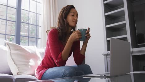 mixed race woman enjoying drinking tea. social distancing and self isolation in quarantine