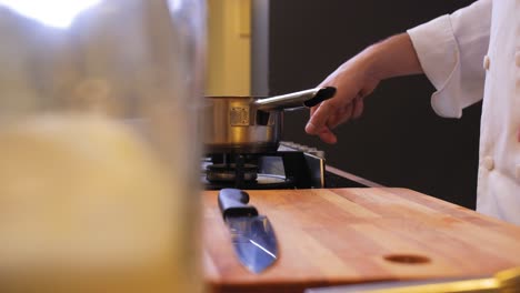el cocinero enciende el gas debajo de una olla