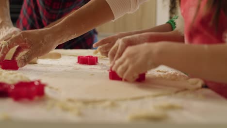 vista de mano de los niños que ayudan a sus padres a hacer galletas