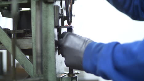 A worker using a machine to drill into a metal piece