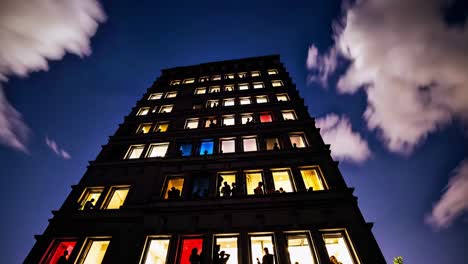 people in windows of high-rise building at night