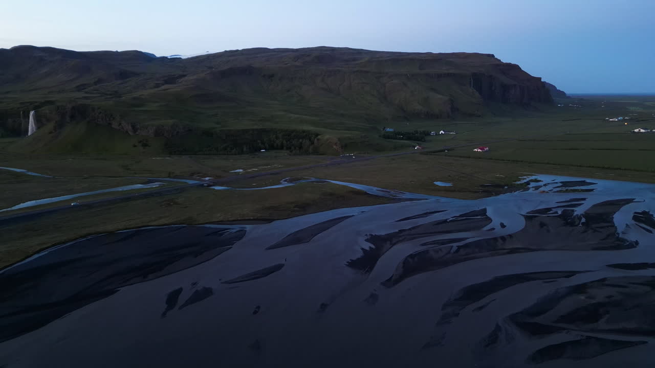 Drone view of Seljalandsfoss, Iceland at dusk, vast landscape, serene mood