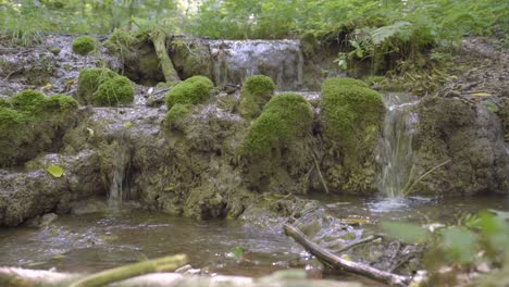 Überlauf-Eines-Kleinen-Baches-Fließt-über-Einen-Kleinen,-Erodierenden,-Schlammigen-Felsvorsprung