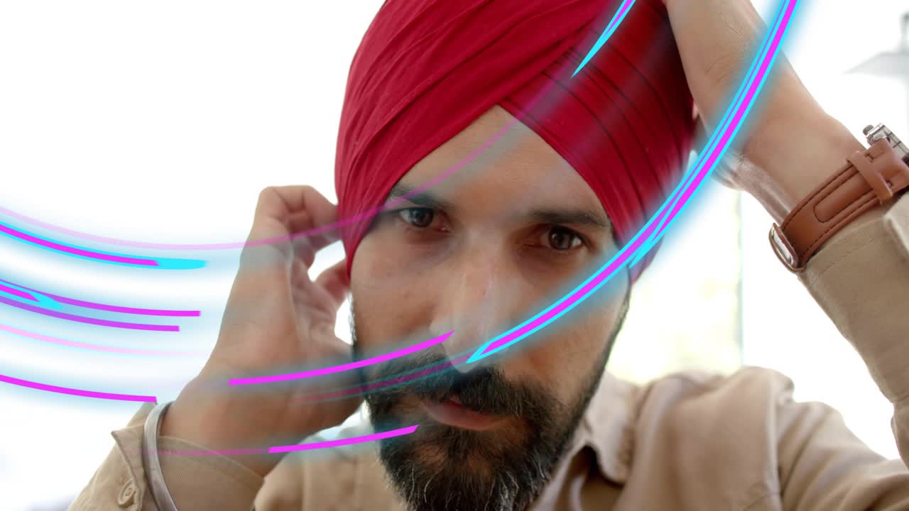 Businessman raising hands to adjust turban, checking fit while neon streaks sweeping across face