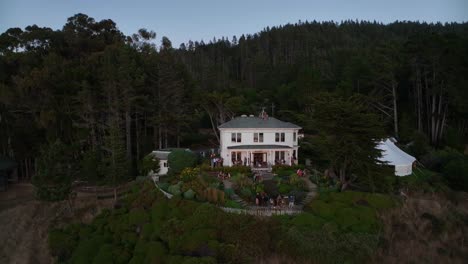 orbiting aerial shot of a private mansion on the california coast rented out as a wedding reception venue