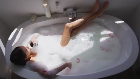 woman drinking coffee while relaxing in a bathtub