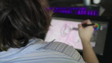 an over-the-shoulder shot of a caucasian woman drawing a digital illustration on a tablet in slow motion