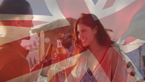 animation of diverse friends at beach over flag of great britain