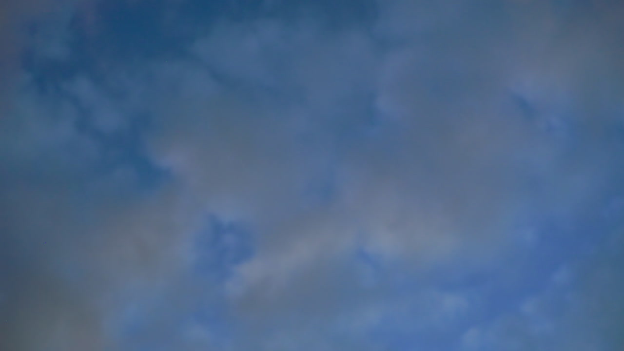 Majestic view of evening sky filled with soft drifting clouds under fading daylight, creating peaceful blue and gray tones perfect for conveying tranquility, nature, and serene atmosphere