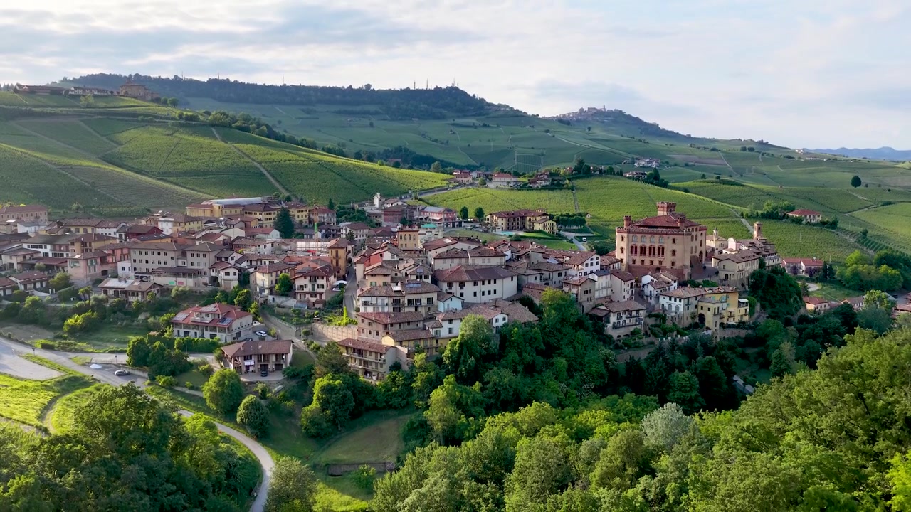 Bred luftoptagelse fanger den historiske landsby Barolo og frodige grønne vinbakker