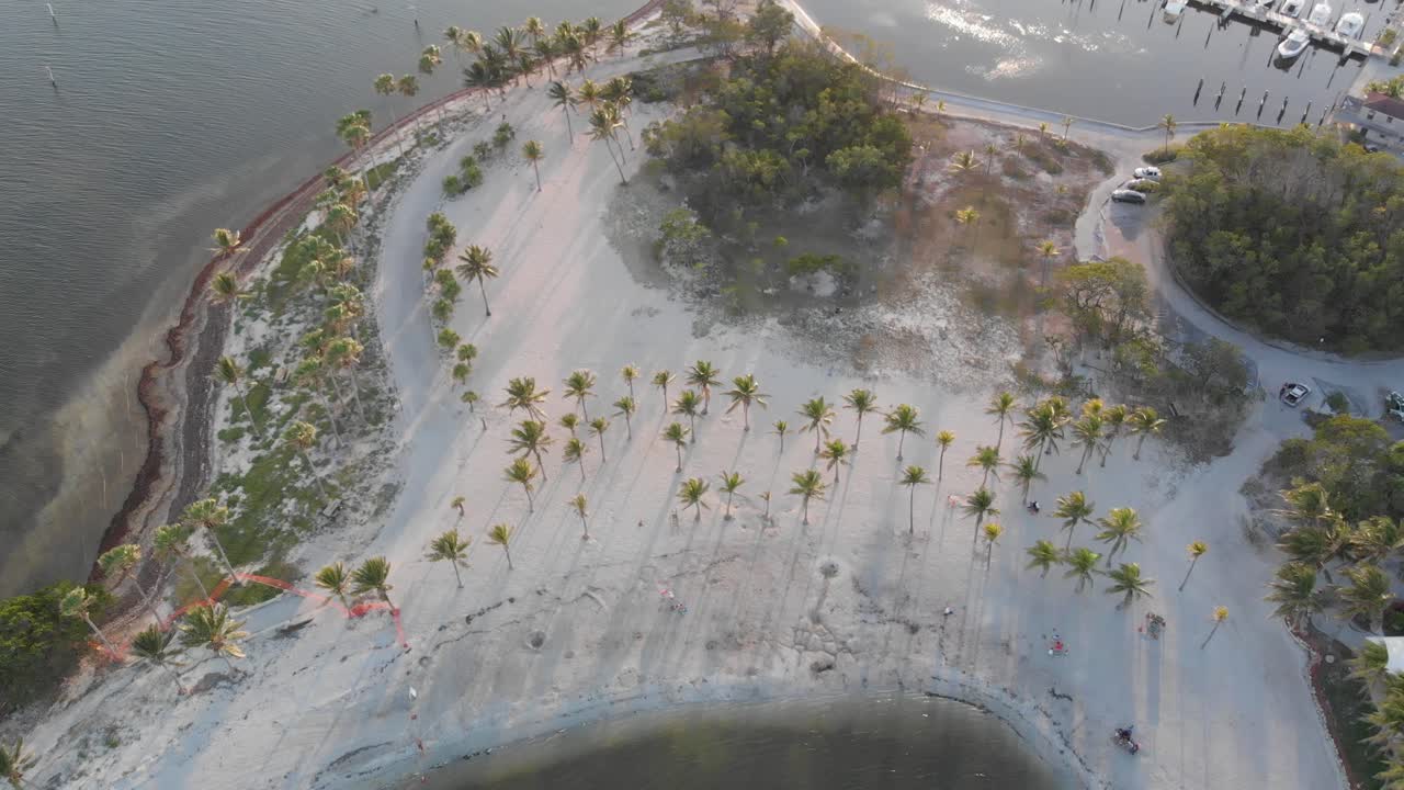 Vista aérea de un parque de playa y el océano con un muelle de marina