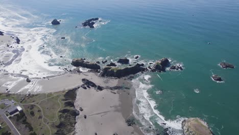 high wide view of bandon oregon coast on a sunny day waves crash on sandy beach