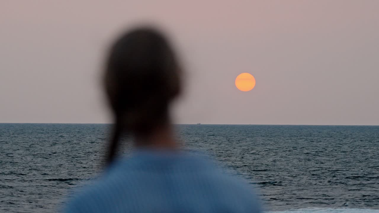 A serene moment in Galle, Sri Lanka, as a woman gazes at the vast ocean during a breathtaking sunset.
