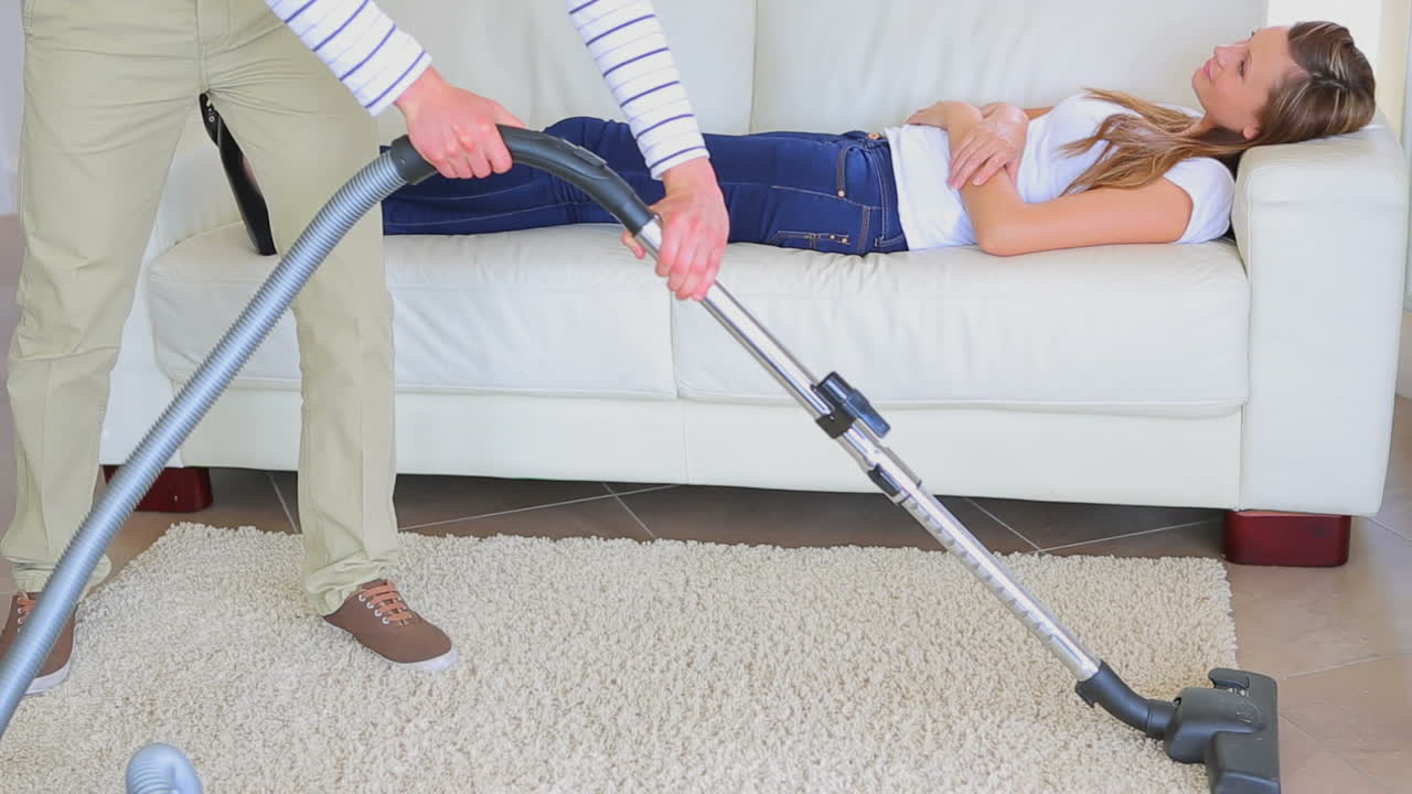 Mulher tirando uma soneca enquanto homem faz as tarefas domésticas