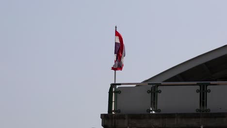 thai flag fluttering on a building's edge