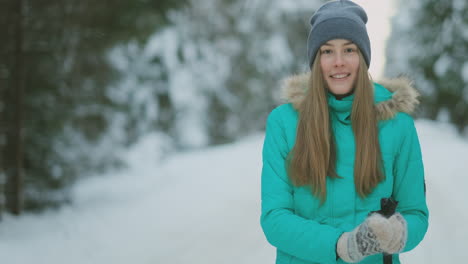 Waist-up-portrait-of-beautiful-young-woman-smiling-happily-looking-at-camera-while-enjoying-skiing-in-snowy-winter-forest,-copy-space