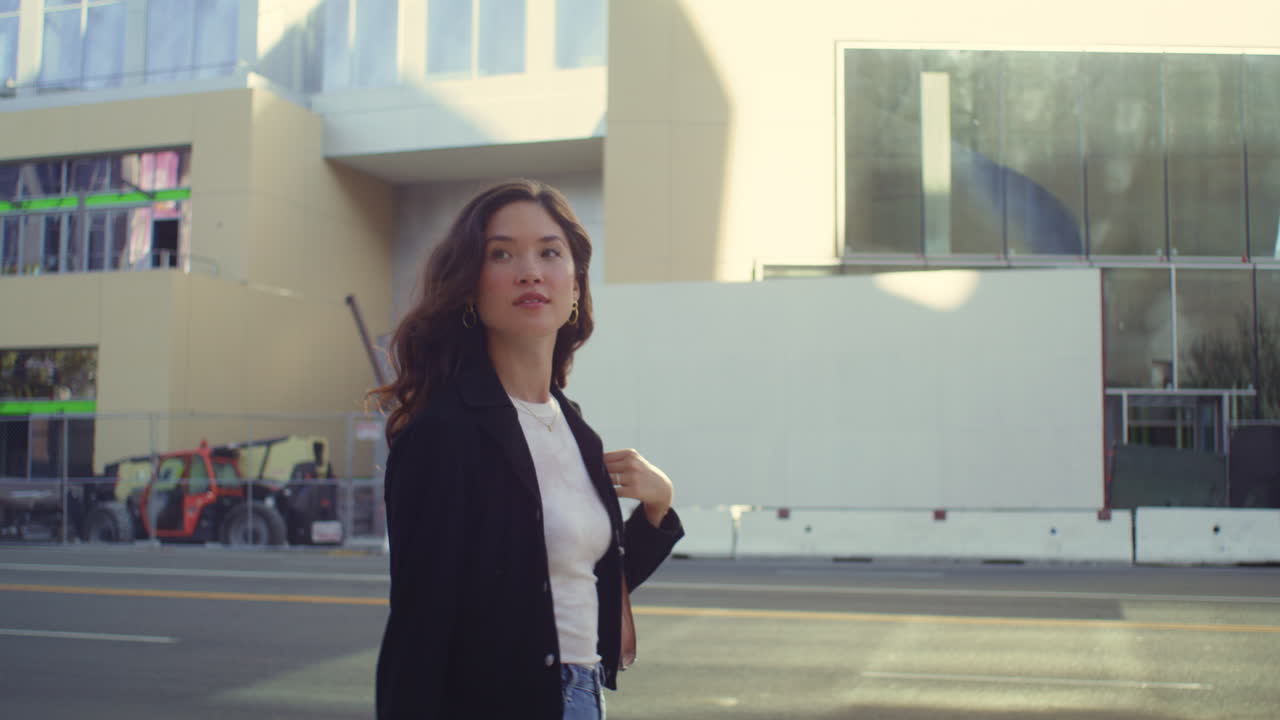 현대적인 도시 거리를 탐험하는 세련된 여성. 행복한 웃는 소녀가  ⁇ 는 것을 즐긴다.