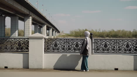 arabian woman with chiffon headscarf enjoys river view