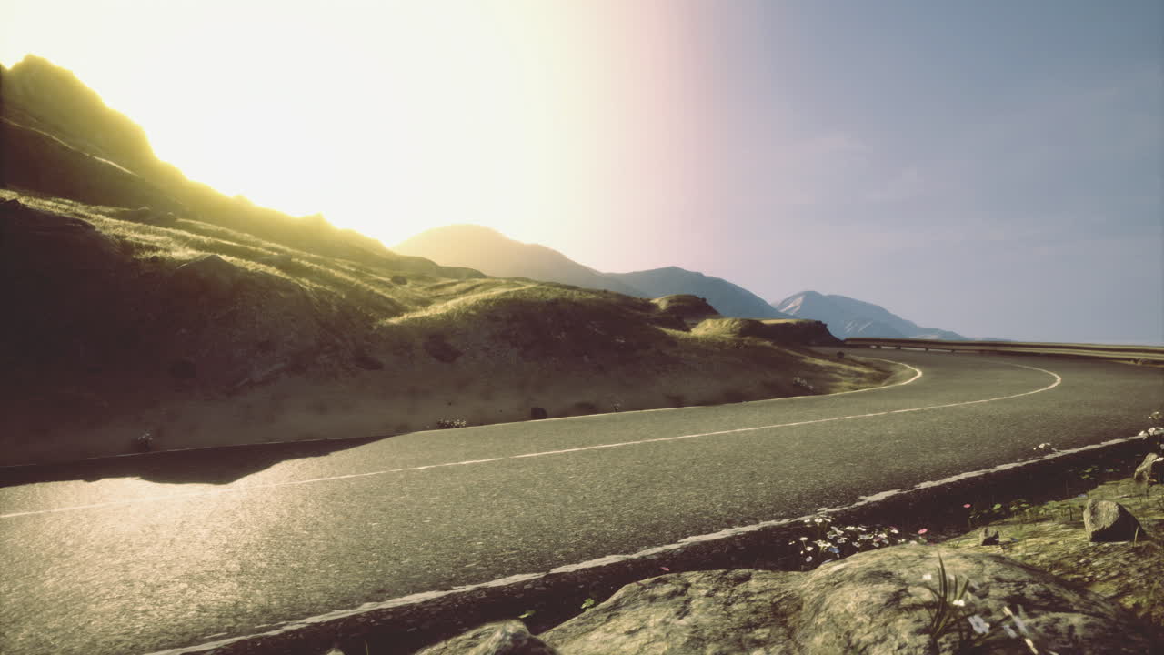 Mountain road at sunset with golden light illuminating the landscape