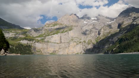 Vista-Panorámica-Del-Paisaje-De-La-Montaña-Blümisalp-Y-El-Lago-Oeschinen,-El-Agua-Ondulada-Y-El-Pico-De-Las-Montañas-Rocosas