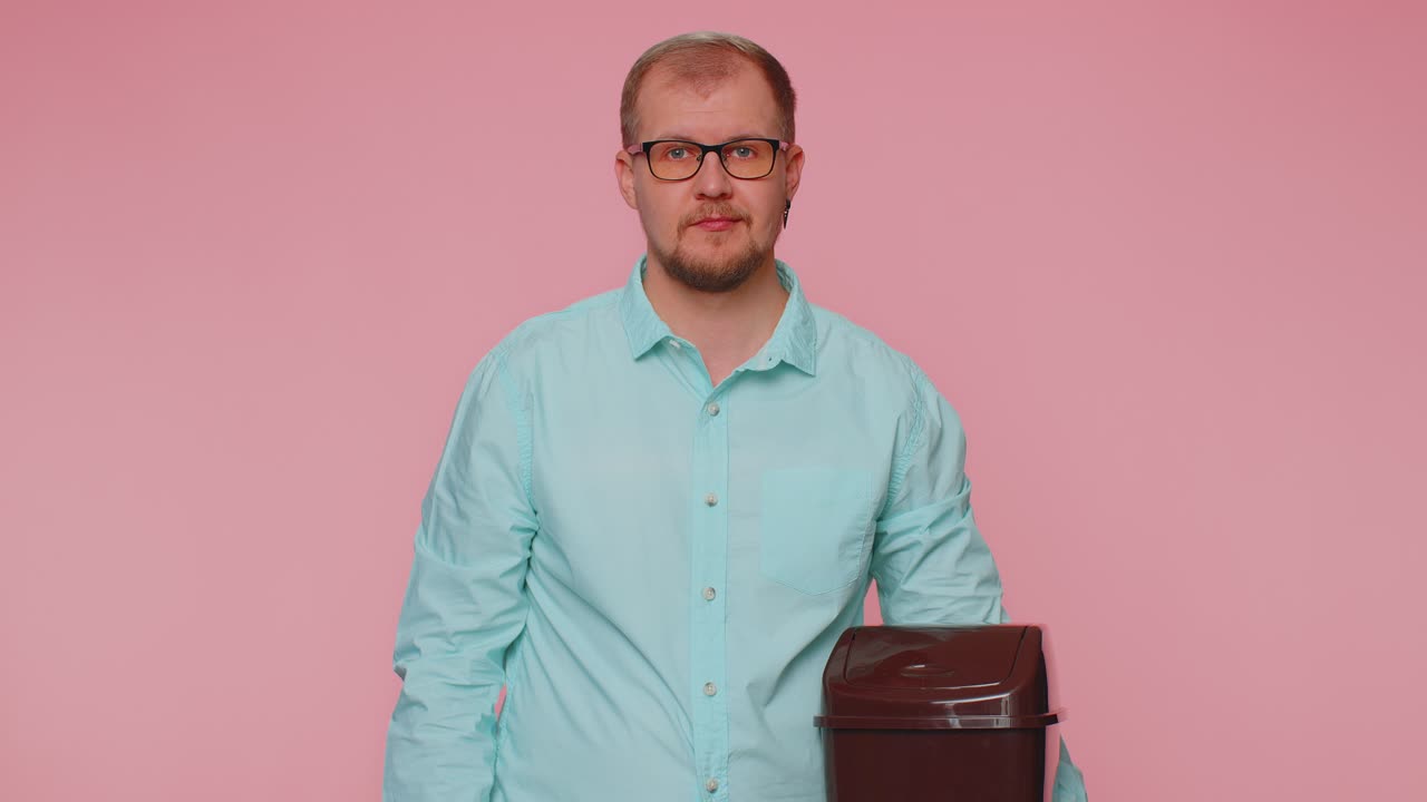 Smiling man taking off throwing out glasses into bin after vision laser treatment therapy