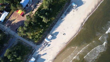 Bird's-Eye-View-Of-Ocean-Waves-Splashing-Sandy-Shore-Of-The-Beach-In-Krynica-Morska,-Poland---drone-shot