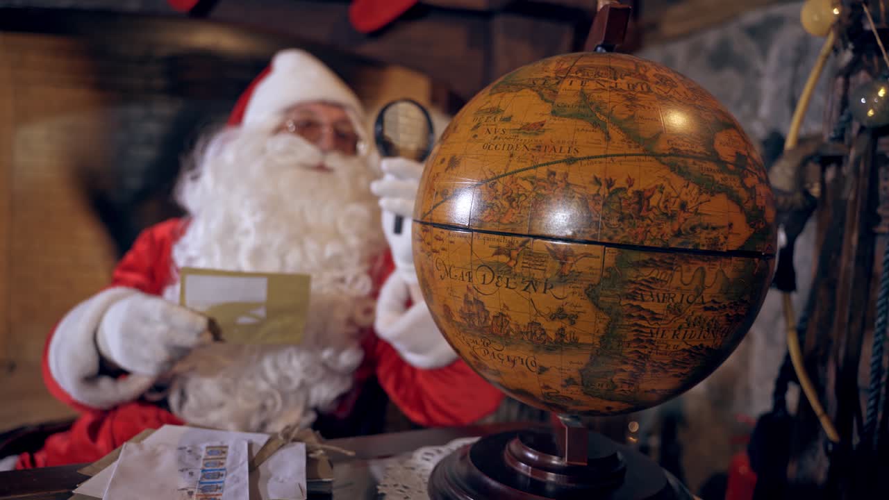 Santa Claus with globe in room. Santa Claus at his home making plans of travelling around the planet