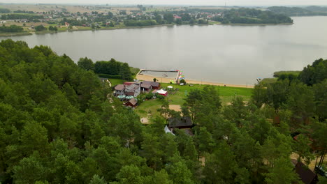 Toma-Aérea-Del-Paisaje-Rural-Con-Playa-De-Arena-Natural-Y-Embalse-De-Lago-Natural-En-Segundo-Plano