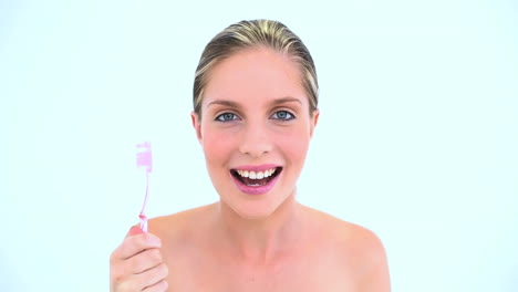 blond woman brushing her teeth