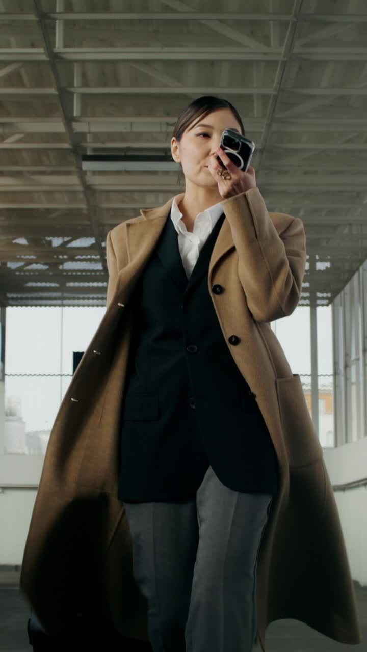 mujer de negocios caminando y hablando por teléfono en un entorno urbano moderno