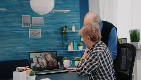 happy senior couple waving during video conference with nephews