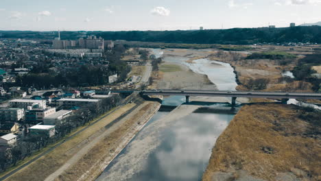 Aerial-View-Of-Traffic-In-Mutsumi-Bridge-Over-Shallow-River-In-Tokyo,-Japan