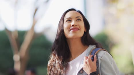 Asian-woman-looking-around-and-smiling-on-a-sunny-day