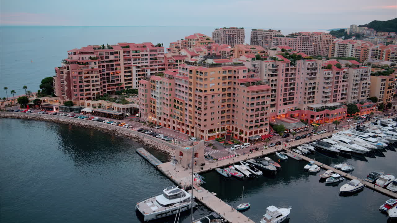 Aerial view of boats docked in the Port de Fontvieille with the skyline of Monaco on the background in the evening