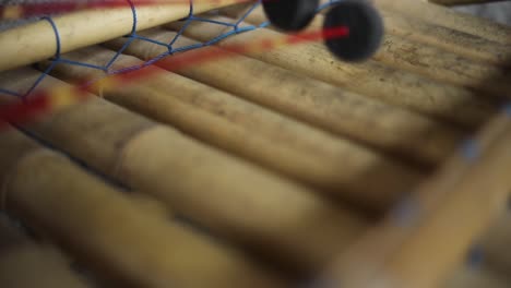 slow motion handheld shot of someone playing an indonesian xylophone