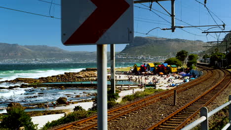 Fahren-Sie-Entlang-Der-Eisenbahnstrecke-Mit-Den-Farbenfrohen,-Ikonischen-Strandhütten-Von-St.-James-In-Der-False-Bay