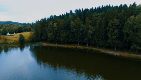 Drone-Se-Eleva-Sobre-El-Hermoso-Panorama-Del-Lago-Al-Bosque-Y-La-Vista-Aérea-De-Las-Colinas